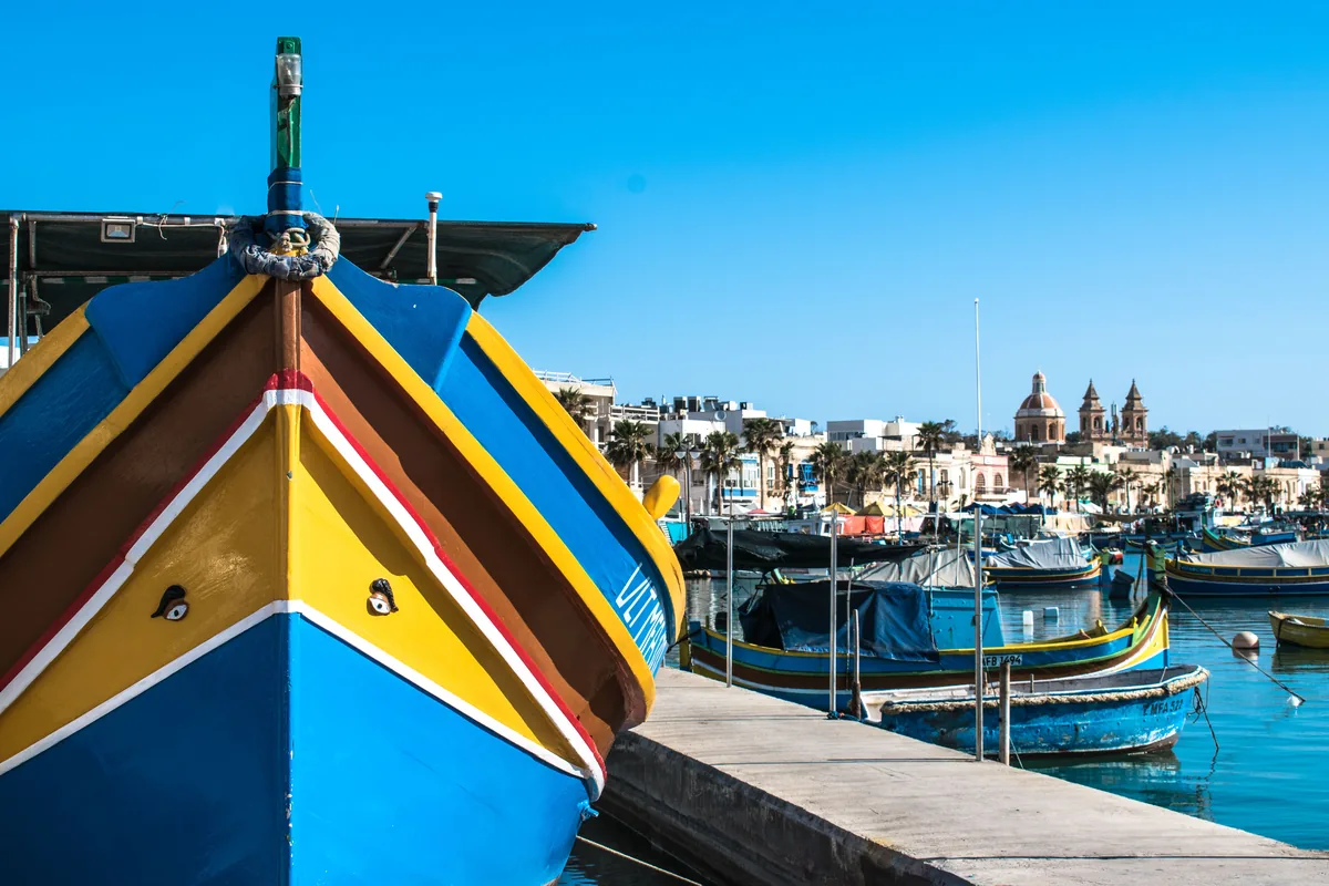 Traditional painted luzzu fishing boats in a Maltese harbour, representative of Malta's boat-painting tradition