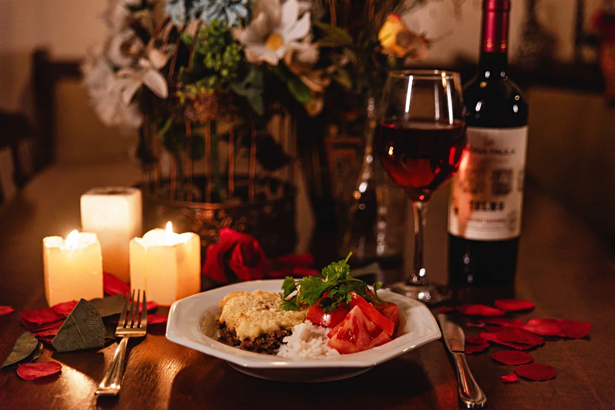 A candlelit dinner table set with wine, representative of an evening restaurant meal
